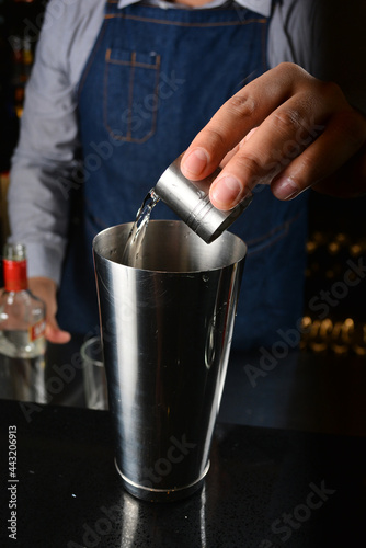 bartender make special cold cocktail or mocktail in tall glass goblet on black background luxury hotel pub iced beverage menu
