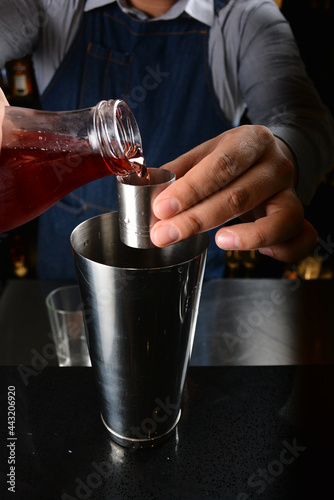 bartender make special cold cocktail or mocktail in tall glass goblet on black background luxury hotel pub iced beverage menu