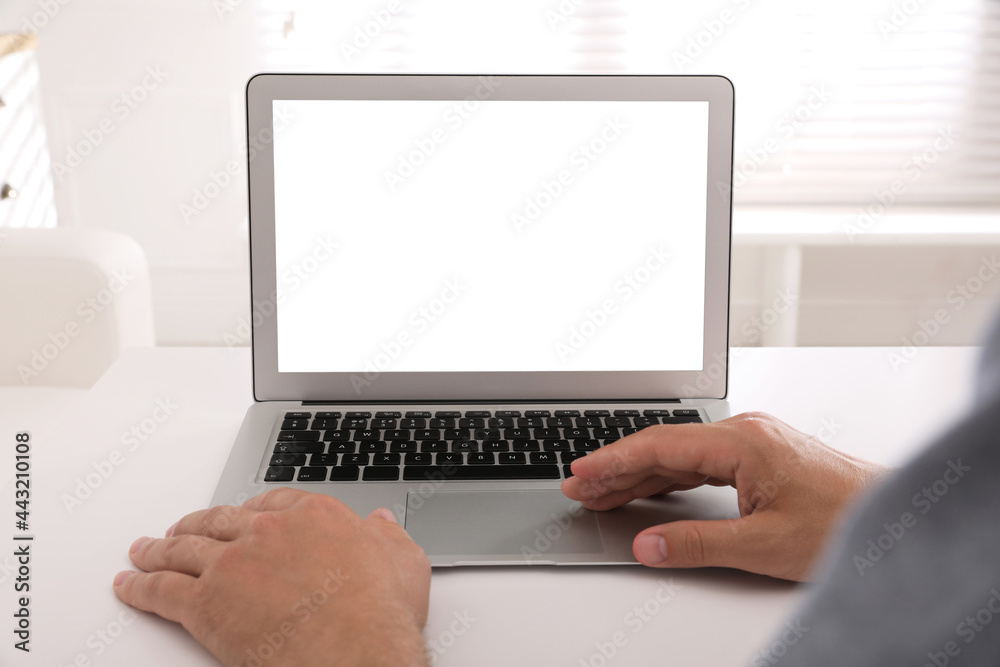Man with modern laptop at white table indoors, closeup. Space for design Man with modern laptop at white table indoors, closeup. Space for design