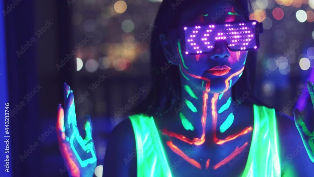 Neon  asian woman dancing. Fashion model woman in neon light, portrait of beautiful model with fluorescent make-up, Art and future design of female disco dancer posing in UV, colorful make up.