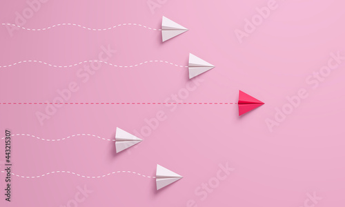 Women's leadership concepts with red paper airplane leading among white on pink background.