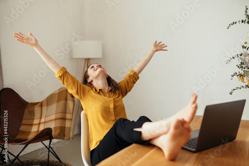 Happy carefree young woman celebrating with spread arms