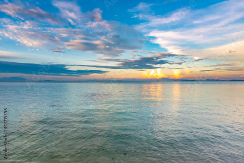 Nature in twilight period which including of sunrise over the sea and the nice beach. Summer beach with blue water and purple sky at the sunset.	
