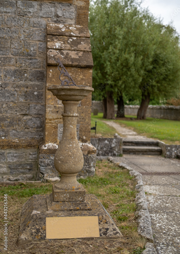 Close and selective focus on a sun dial outside a small church in the Somerset countryside