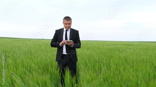 Businesswoman in suit inspecting farmland with tablet. Ecoculture farm. photo