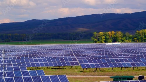 The concept of low-cost and efficient solar energy. Solar panels, mountains in the background. The development of alternative energy in the world energy sector. High quality. 4k footage.