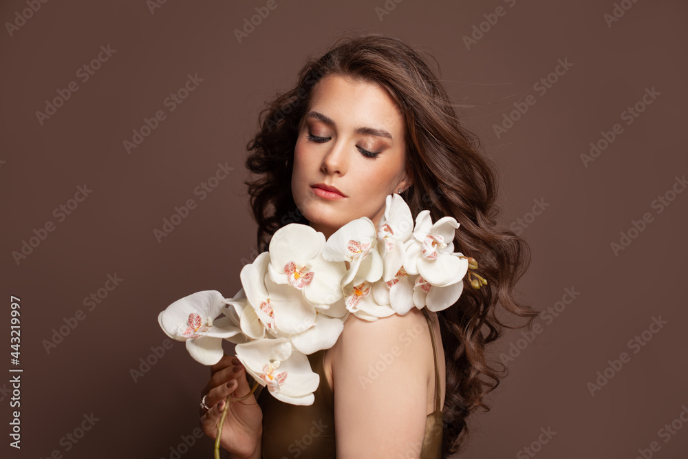 Young beautiful woman with bouquet of white flowers. Professional art makeup and perfect curly hairstyle