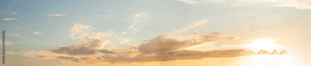 Orange and blue sky with sun and clouds background