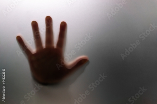 Silhouette of hand behind glass foregroundSilhouette of hand behind glass foreground © javidestock