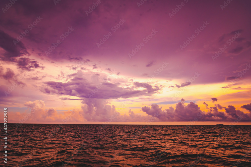 Nature in twilight period which including of sunrise over the sea and the nice beach. Summer beach with blue water and purple sky at the sunset.	
