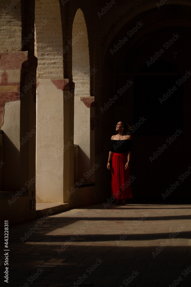 young woman walking inside an ancient building in Spain