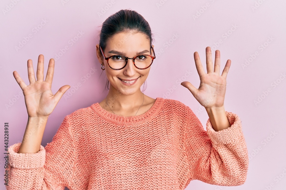 Young caucasian woman wearing casual clothes and glasses showing and pointing up with fingers number ten while smiling confident and happy. Young caucasian woman wearing casual clothes and glasses showing and pointing up with fingers number ten while smiling confident and happy.