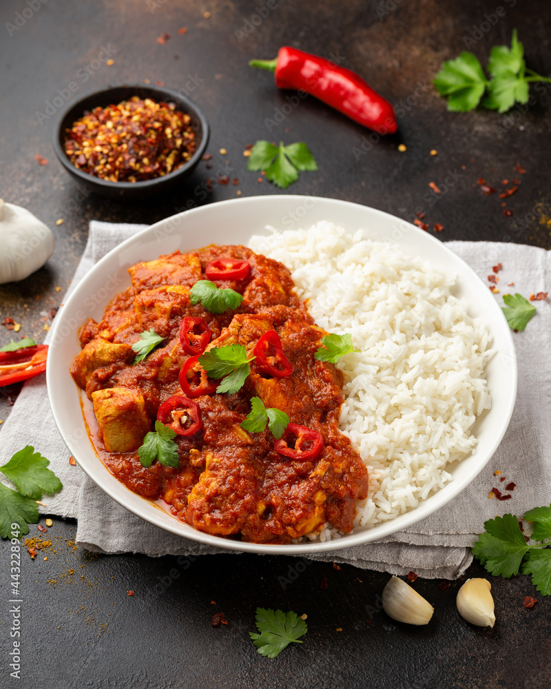 Spicy Chicken Pathia curry with basmati rice in a white plate. healthy food. Spicy Chicken Pathia curry with basmati rice in a white plate. healthy food.