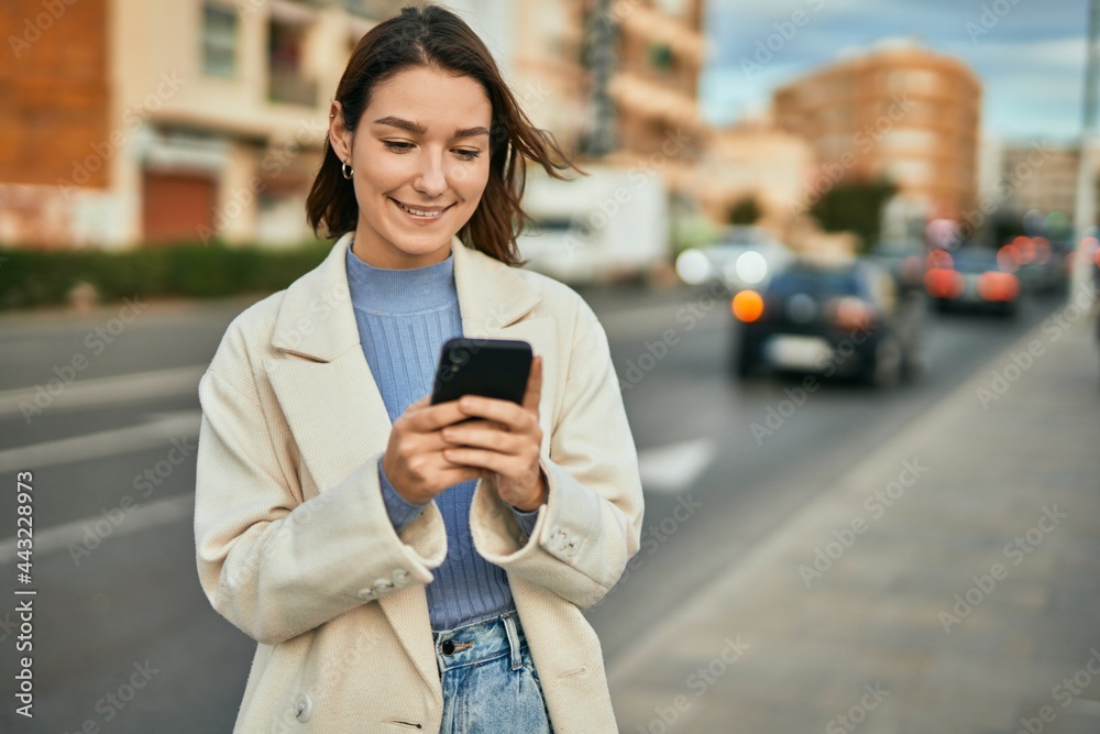 Young hispanic woman smiling happy using smartphone at the city. Young hispanic woman smiling happy using smartphone at the city.