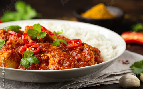Spicy Chicken Pathia curry with basmati rice in a white plate. healthy food.