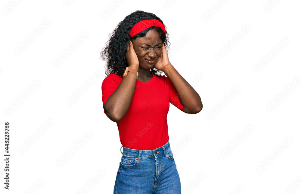 Beautiful african young woman wearing casual clothes covering ears with fingers with annoyed expression for the noise of loud music. deaf concept. Beautiful african young woman wearing casual clothes covering ears with fingers with annoyed expression for the noise of loud music. deaf concept.