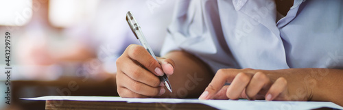 Students writing and reading exam answer sheets exercises in classroom of school with stress photo