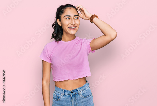 Fotografie Hispanic teenager girl with dental braces wearing casual clothes smiling confide