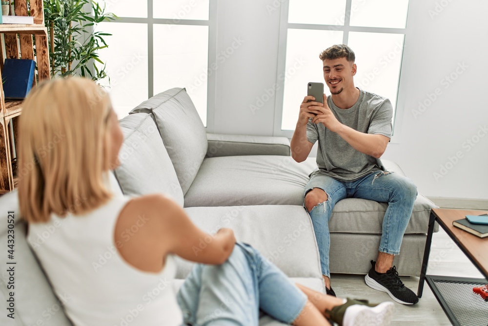 Man making photo to his girlfriend using smartphone at home.