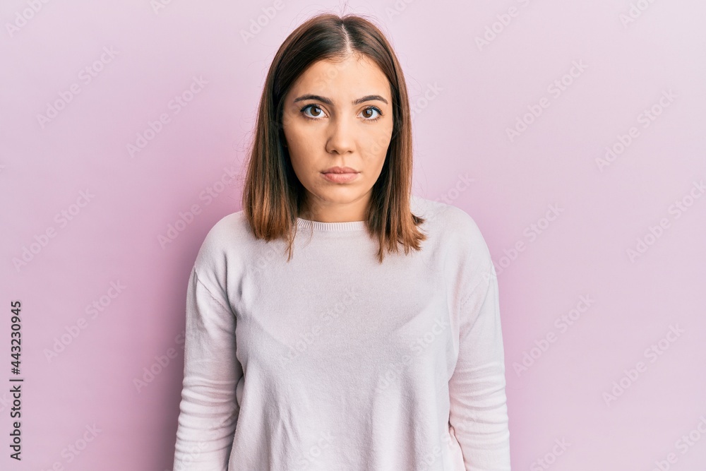 Young beautiful woman wearing casual clothes with serious expression on face. simple and natural looking at the camera. Young beautiful woman wearing casual clothes with serious expression on face. simple and natural looking at the camera.