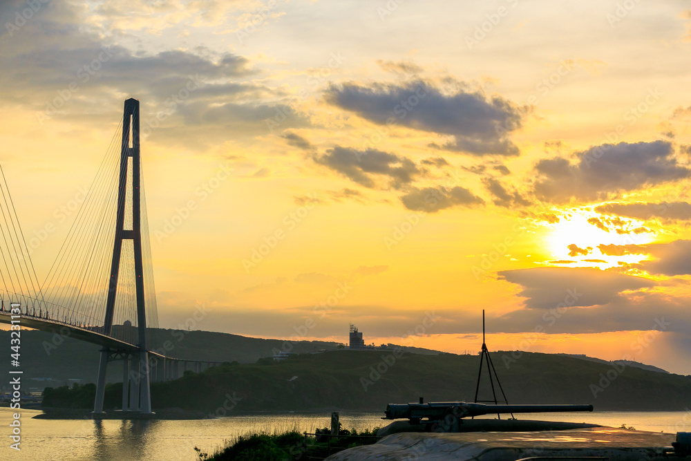 Russian bridge across the Eastern Bosphorus Strait in Vladivostok. Russian bridge to the Russky island against the background of a bright dawn.