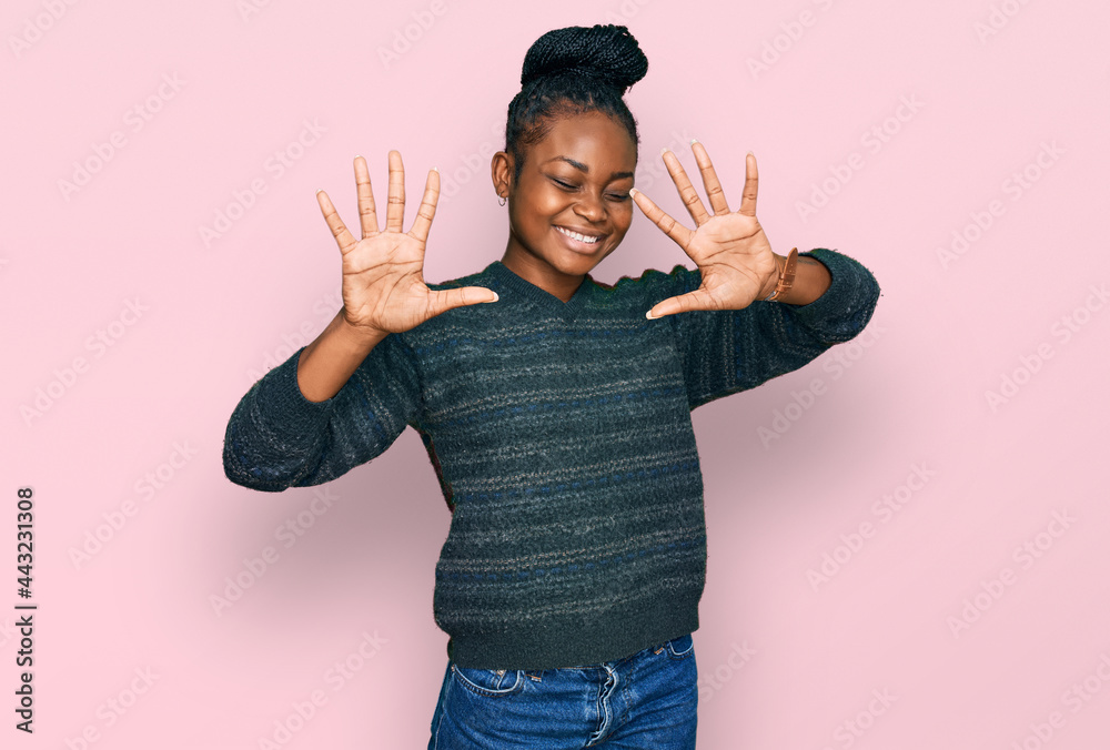 Fototapeta premium Young african american woman wearing casual clothes showing and pointing up with fingers number ten while smiling confident and happy.