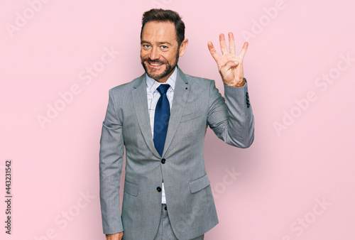 Middle age man wearing business clothes showing and pointing up with fingers number four while smiling confident and happy.