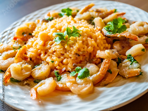 Risotto with shrimps and parsley on wooden table
