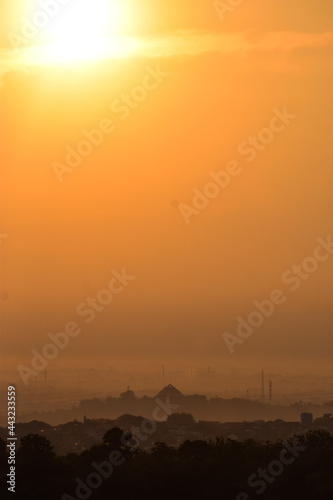 The sun rises over the city of Semarang covered by clouds