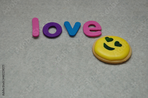 In love emoji with the word love biscuit with the word happy on a white background
