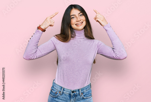 Young beautiful teen girl wearing turtleneck sweater smiling pointing to head with both hands finger, great idea or thought, good memory