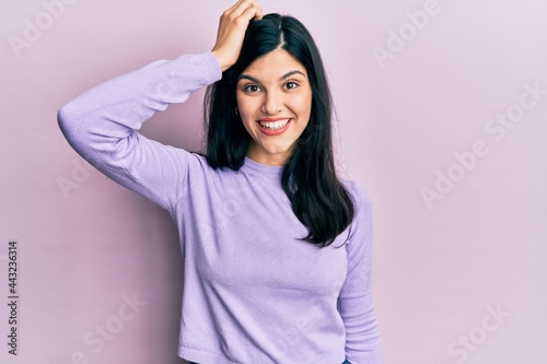 Young hispanic woman wearing casual clothes smiling confident touching hair with hand up gesture, posing attractive and fashionable © Krakenimages.com