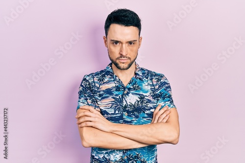 Young hispanic man wearing casual clothes skeptic and nervous, disapproving expression on face with crossed arms. negative person.