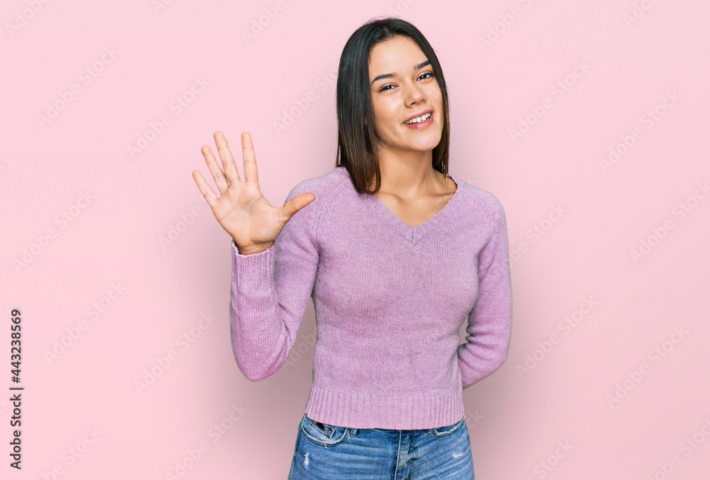 Young hispanic girl wearing casual clothes showing and pointing up with fingers number five while smiling confident and happy. Young hispanic girl wearing casual clothes showing and pointing up with fingers number five while smiling confident and happy.
