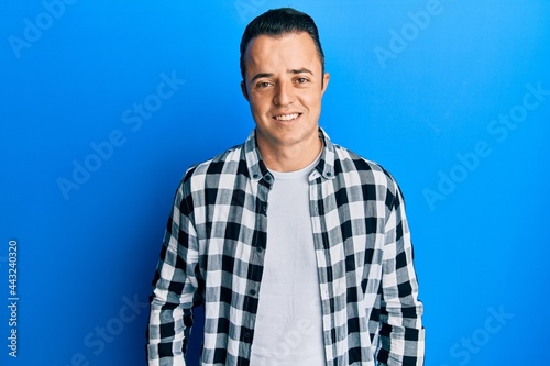 Handsome young man wearing casual shirt with a happy and cool smile on face. lucky person.