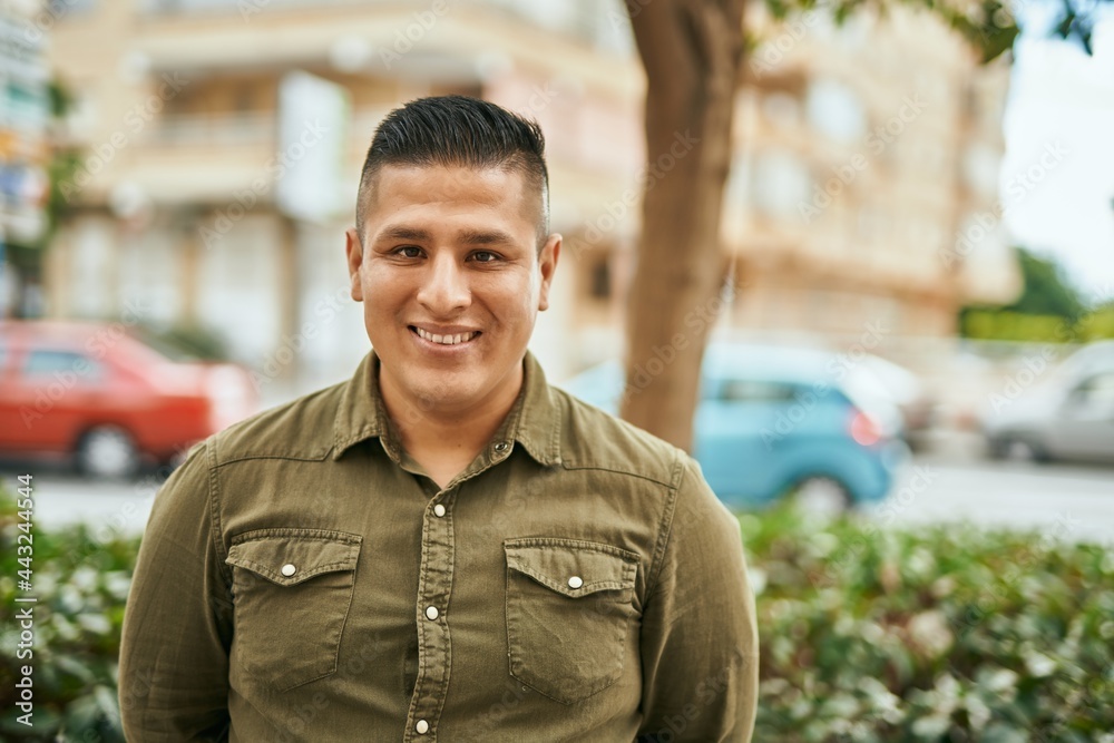 Fototapeta premium Young latin man smiling happy standing at the city.