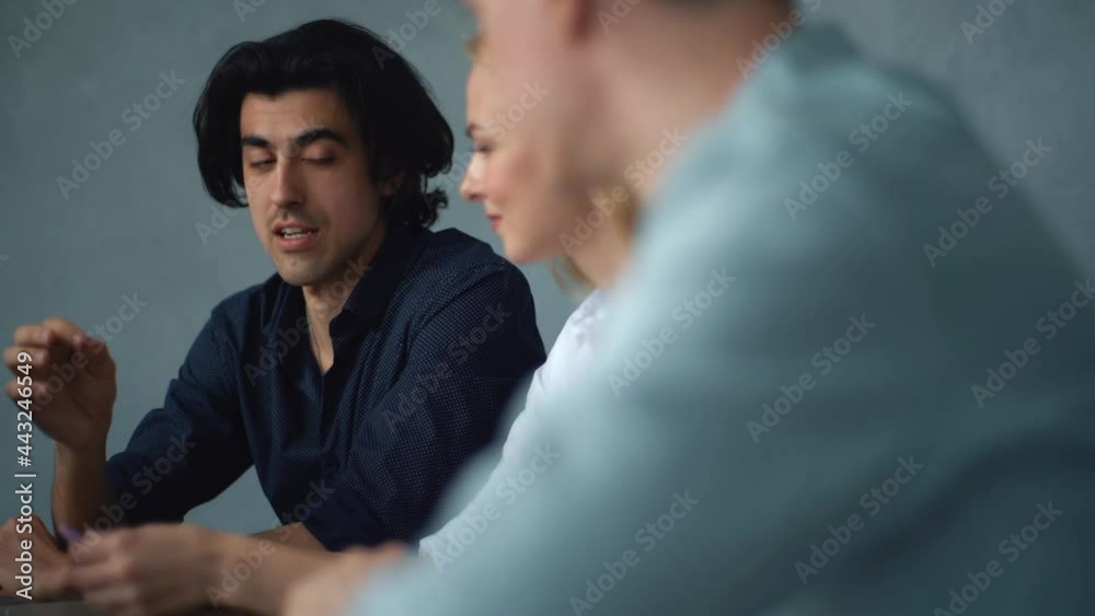 Close-up of three female and male manager work at table with laptop at office, discussing business tasks. Tracking shot of young business team discussing plans sitting at desk in conference room. Close-up of three female and male manager work at table with laptop at office, discussing business tasks. Tracking shot of young business team discussing plans sitting at desk in conference room.