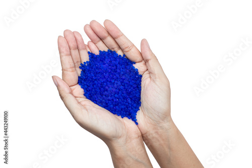 Close up of hand holding blue silica gel on white background, Granular Desiccant attract moisture for chemical.