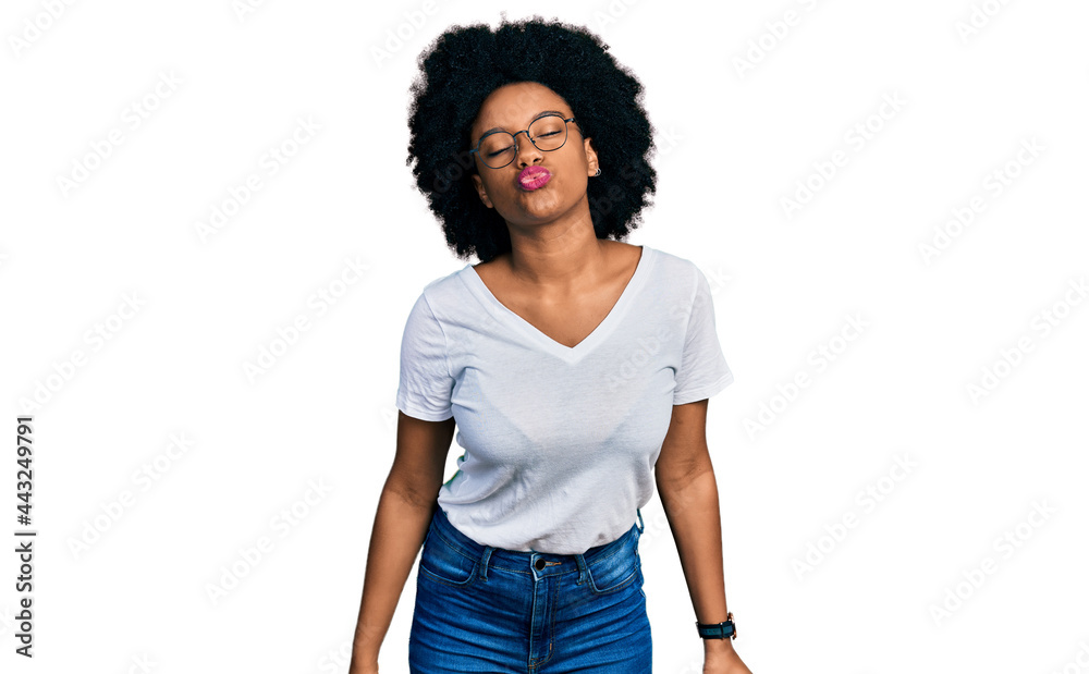 Young african american woman wearing casual white t shirt looking at the camera blowing a kiss on air being lovely and sexy. love expression.