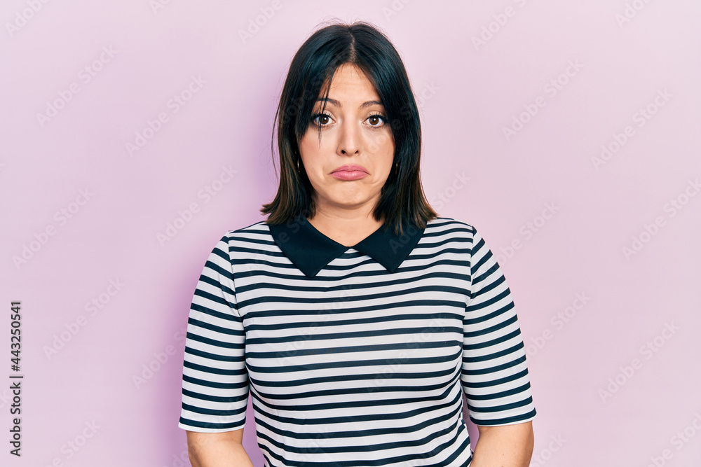 Fototapeta premium Young hispanic woman wearing casual clothes depressed and worry for distress, crying angry and afraid. sad expression.