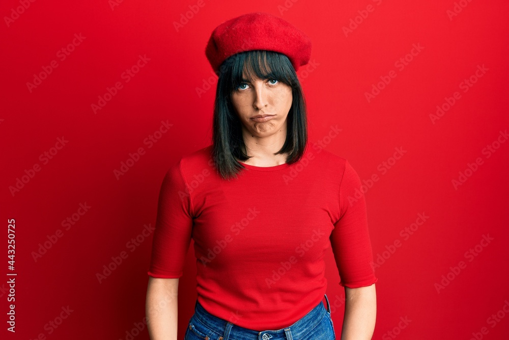 Young hispanic woman wearing french look with beret depressed and worry for distress, crying angry and afraid. sad expression. Young hispanic woman wearing french look with beret depressed and worry for distress, crying angry and afraid. sad expression.