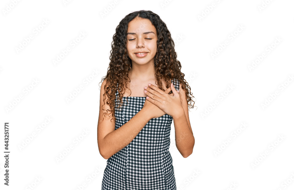 Teenager hispanic girl wearing casual clothes smiling with hands on chest with closed eyes and grateful gesture on face. health concept. Teenager hispanic girl wearing casual clothes smiling with hands on chest with closed eyes and grateful gesture on face. health concept.