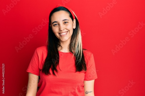 Young hispanic woman wearing casual red t shirt with a happy and cool smile on face. lucky person.