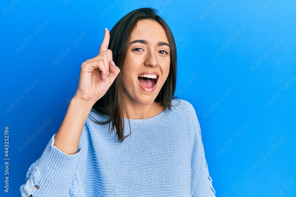 Young hispanic girl wearing casual clothes pointing finger up with successful idea. exited and happy. number one. Young hispanic girl wearing casual clothes pointing finger up with successful idea. exited and happy. number one.
