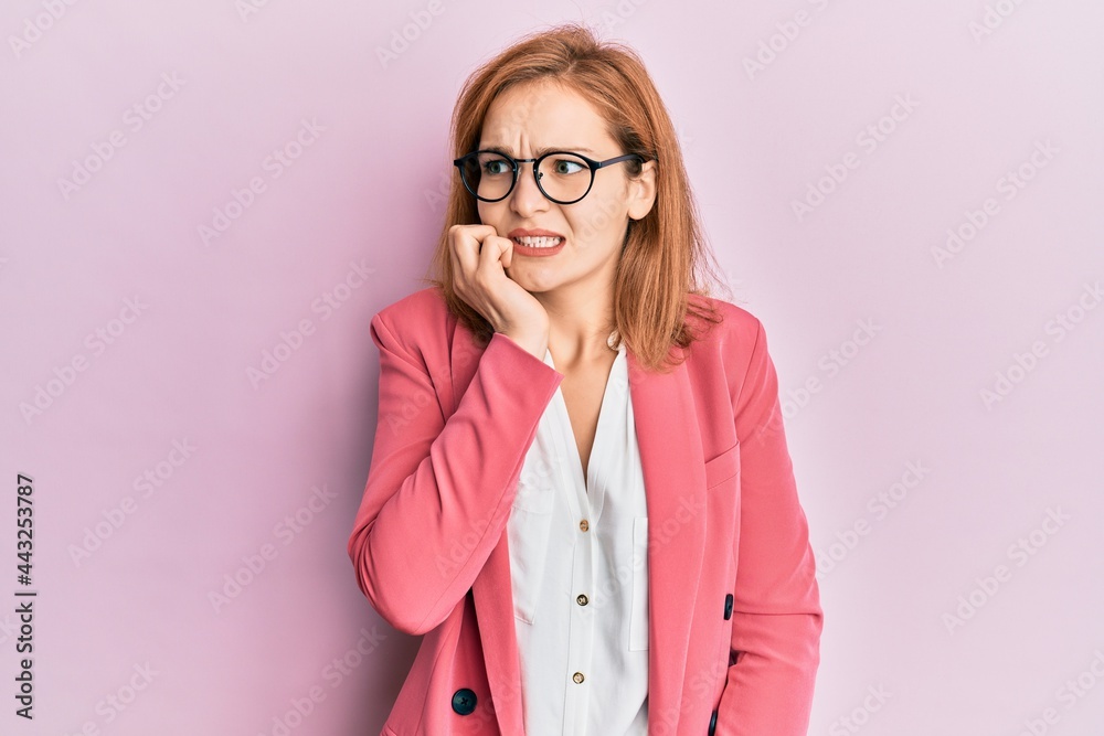 Young caucasian woman wearing business style and glasses looking stressed and nervous with hands on mouth biting nails. anxiety problem.
