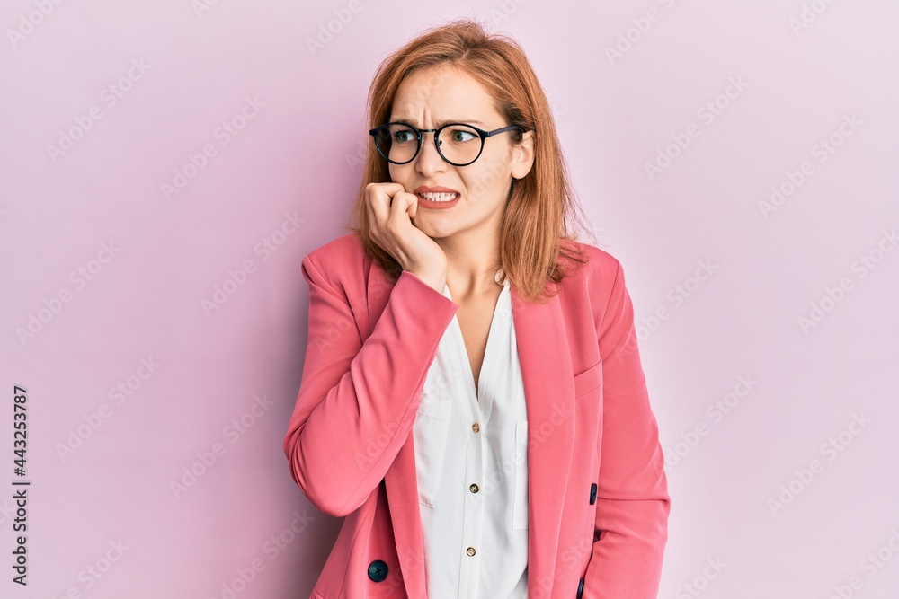 Young caucasian woman wearing business style and glasses looking stressed and nervous with hands on mouth biting nails. anxiety problem. Young caucasian woman wearing business style and glasses looking stressed and nervous with hands on mouth biting nails. anxiety problem.