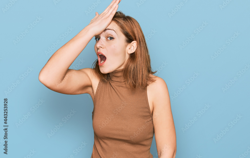 Fototapeta premium Young caucasian woman wearing casual clothes surprised with hand on head for mistake, remember error. forgot, bad memory concept.