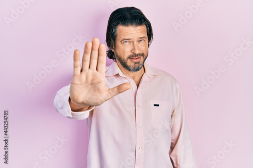 Middle age caucasian man wearing casual clothes doing stop sing with palm of the hand. warning expression with negative and serious gesture on the face.