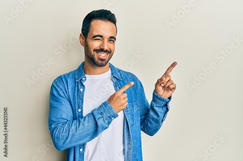 Young hispanic man pointing with fingers to himself winking looking at the camera with sexy expression, cheerful and happy face. photo