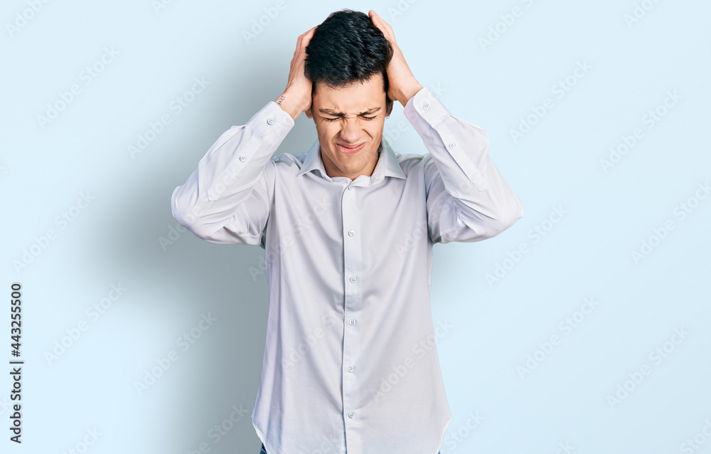Young hispanic business man wearing business clothes suffering from headache desperate and stressed because pain and migraine. hands on head. Young hispanic business man wearing business clothes suffering from headache desperate and stressed because pain and migraine. hands on head.